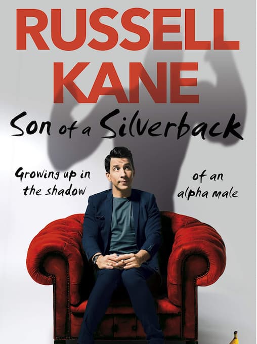 Russell Kane sitting on a chair under book title