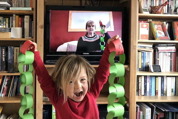 Child playing in front of a TV live stream.