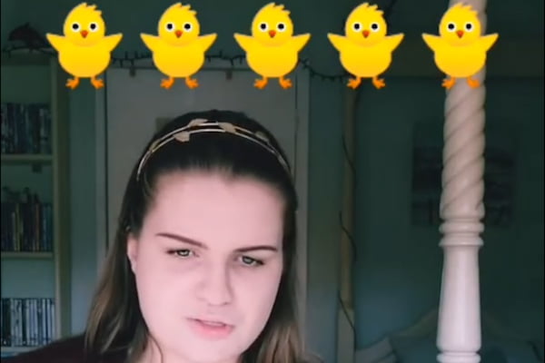 Woman playing a guitar with some duck emojis above her head.