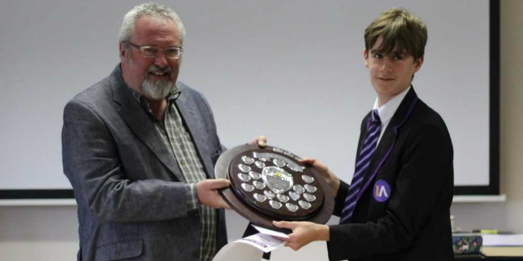 Josh Mayhew receives the Book Mastermind trophy from Suffolk Libraries Board chair Tony Brown