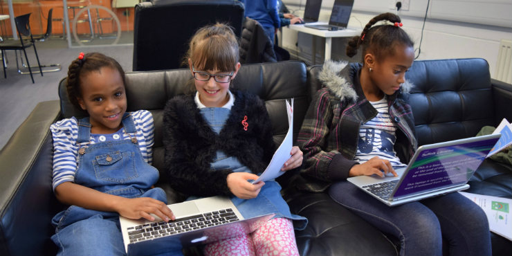 Three girls coding on laptops