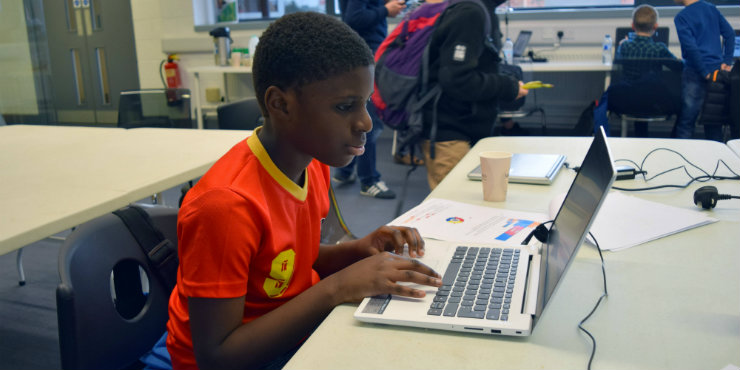 A boy coding on a laptop