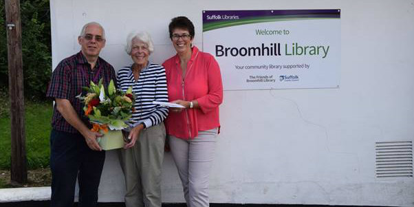 Monica Ford receives her retirement card and flowers from David Cook and Diane Moore