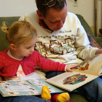 A man reading with a child