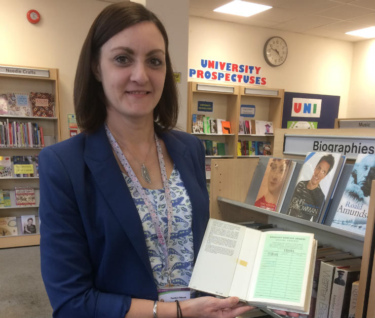 Lowestoft Library staff member Rachel Gibson with <cite>The Metaphysical Poets</cite> by Jim Hunter, which was recently returned 52 years late