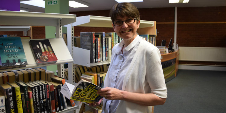 Newmarket Library user Sam Street with an Ian Rankin book at the library