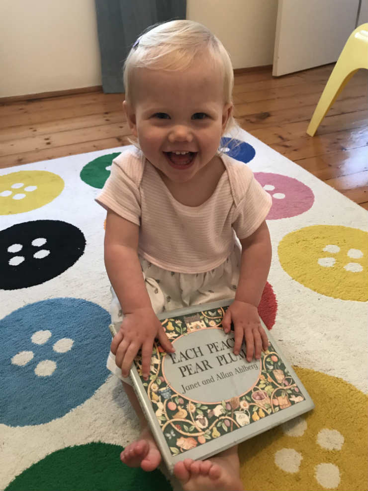 Competition winner Sienna with her favourite book, <cite>Each Peach Pear Plum</cite>