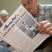 A man reading about sport in a newspaper