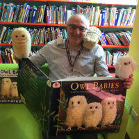 A member of library staff with a big Owl Babies book