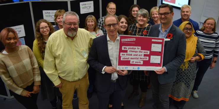 Suffolk Libraries chief executive Bruce Leeke signs the Time to Change pledge with Jon Neal from Suffolk Mind, Suffolk Libraries chairman Tony Brown and Suffolk Libraries staff