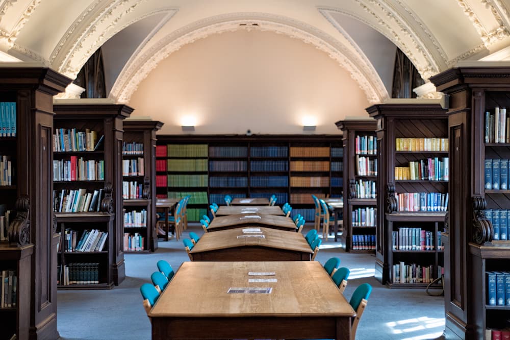 A grand room with an arched ceiling and desks.